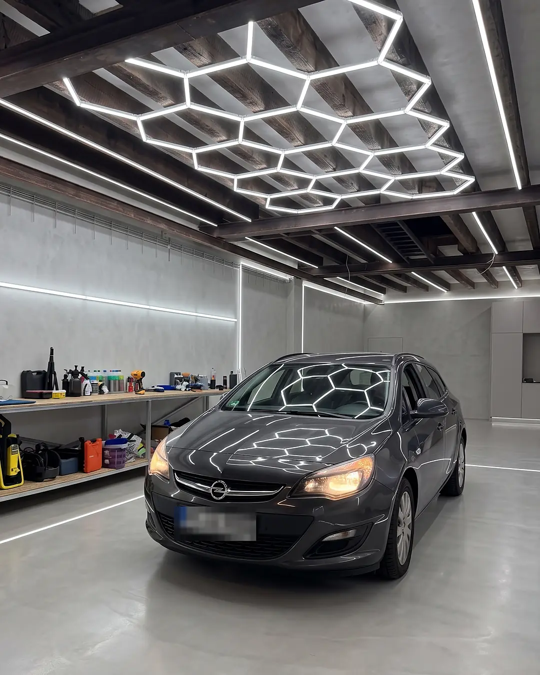 KI-Visualisierung: Opel Astra unter Waben-LED-Licht in einem Detailing-Studio